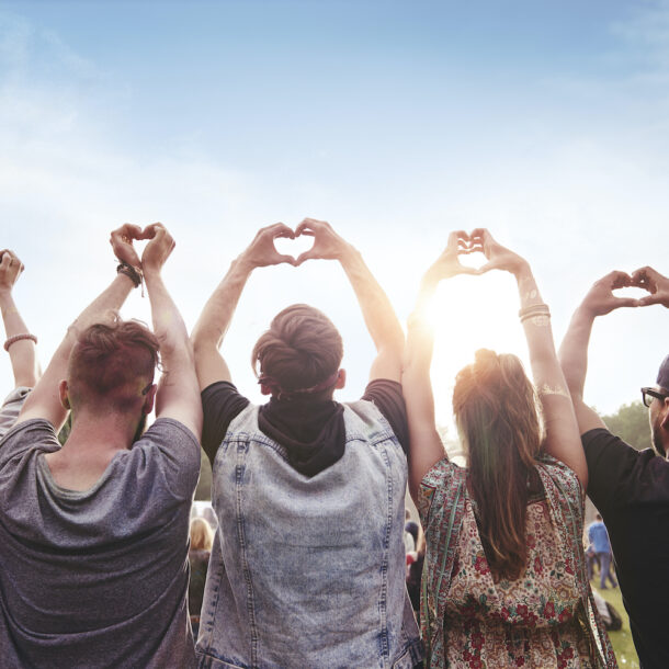 Group of people holding up the heart symbol with their hands.