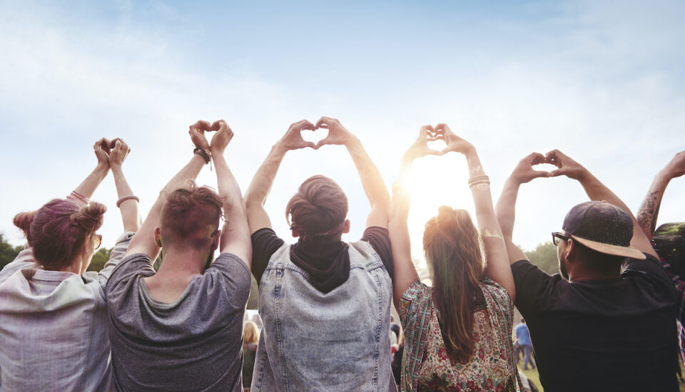 Group of people holding up the heart symbol with their hands.