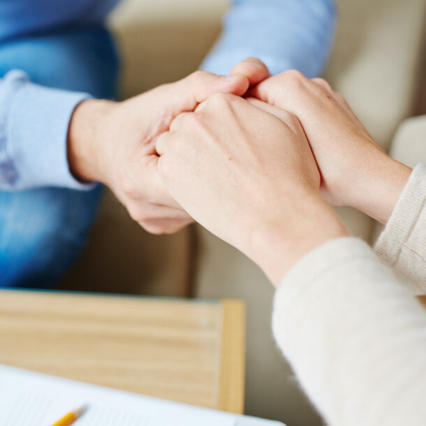 Therapist holding a patient's hands in support