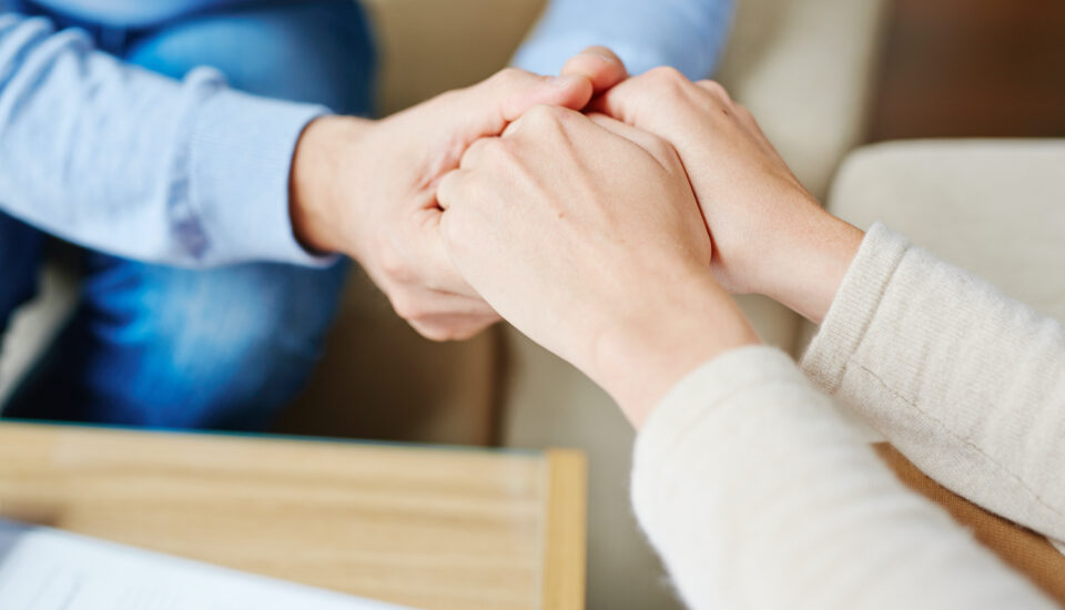 Therapist holding a patient's hands in support