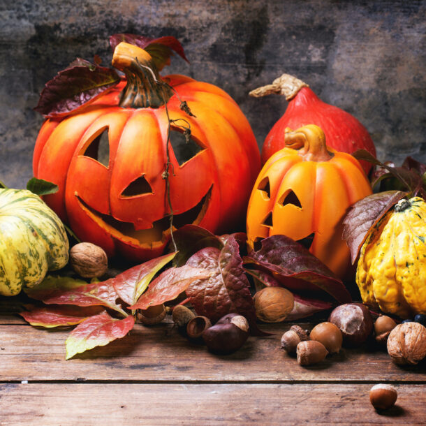 Halloween's pumpkins with autumn leaves on wooden table. See series.