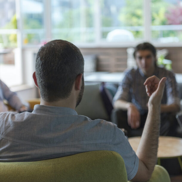 Diverse group of men sitting together talking.