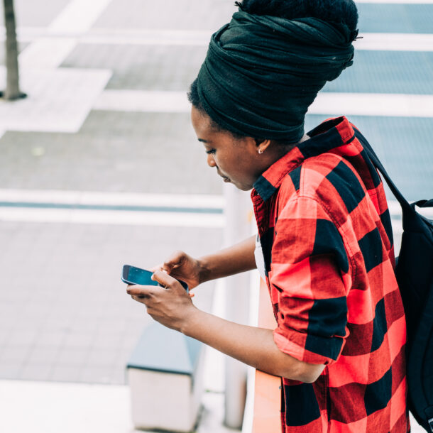 Side view of young beautiful black woman on a smart phone.