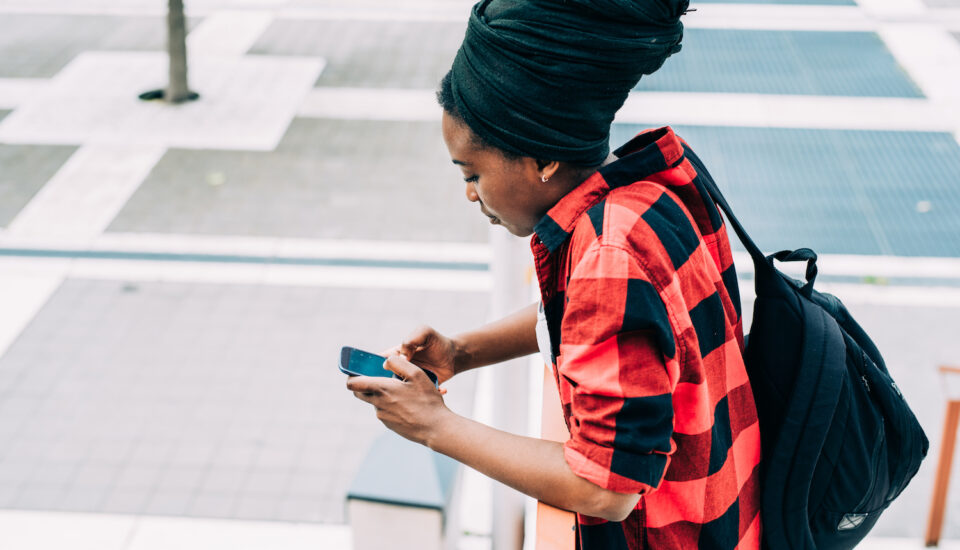 Side view of young beautiful black woman on a smart phone.