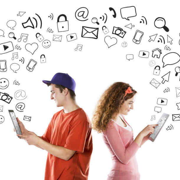 Young couple with tablets and social media icons floating around them.