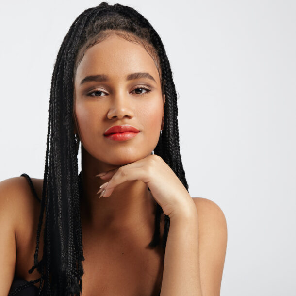 Black woman with braids looking at camera.