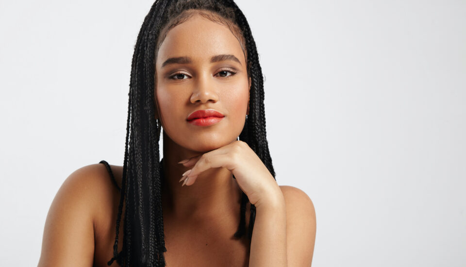 Black woman with braids looking at camera.