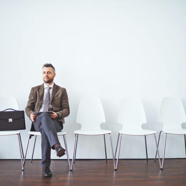 A man in a suit is sitting and waiting for an interview.