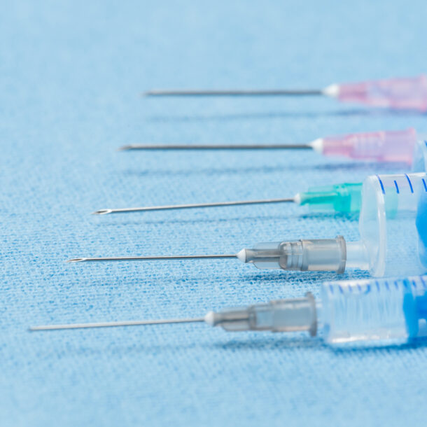 Hypodermic needles injections on blue medical cloth.