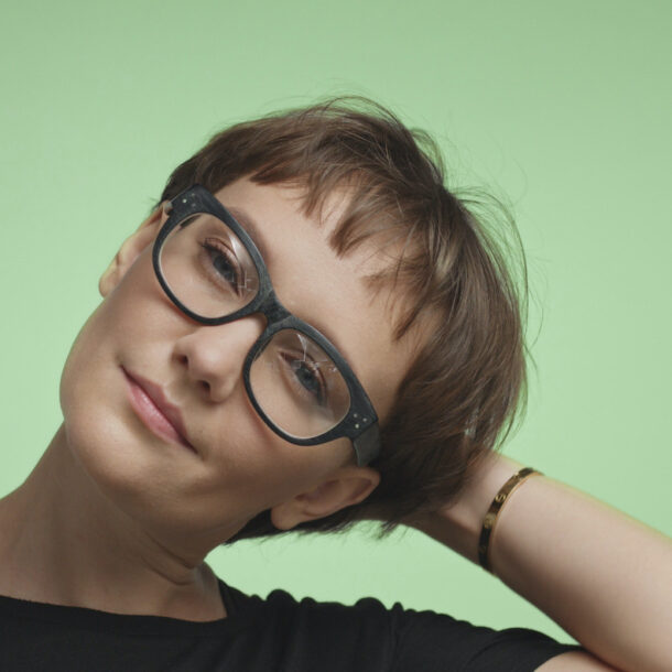 Young woman with short hair on a green background.