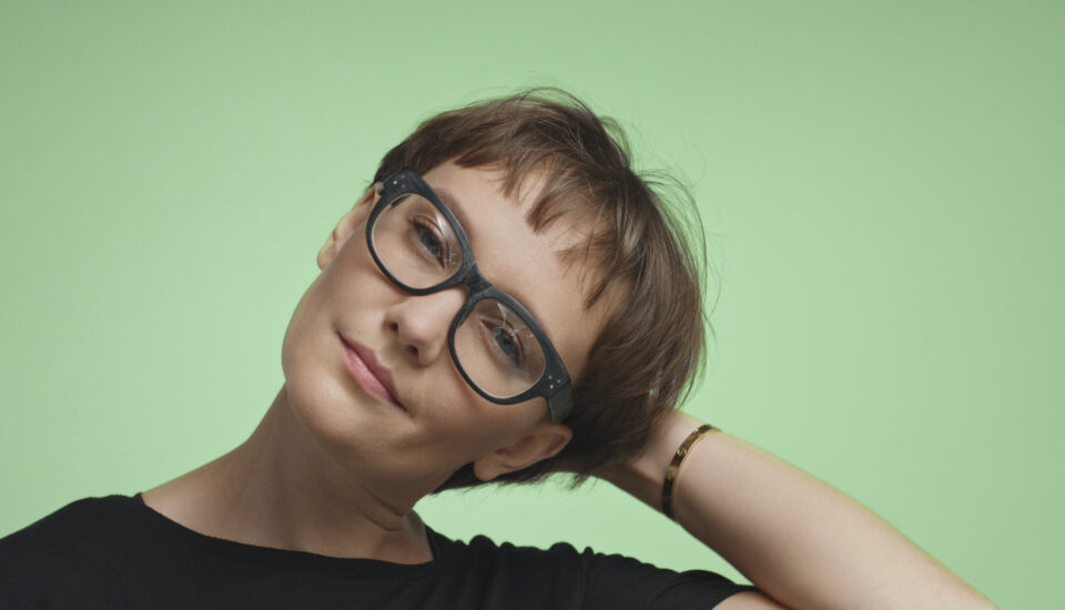 Young woman with short hair on a green background.