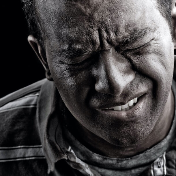 Black and white photo of a man In extreme anguish or pain.