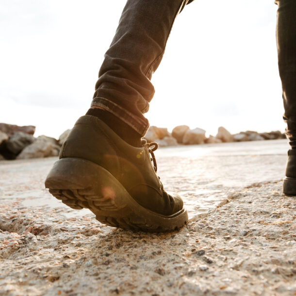 Photo of a young man walking on the beach.