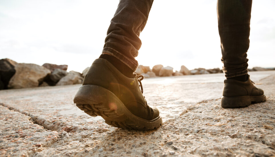 Photo of a young man walking on the beach.