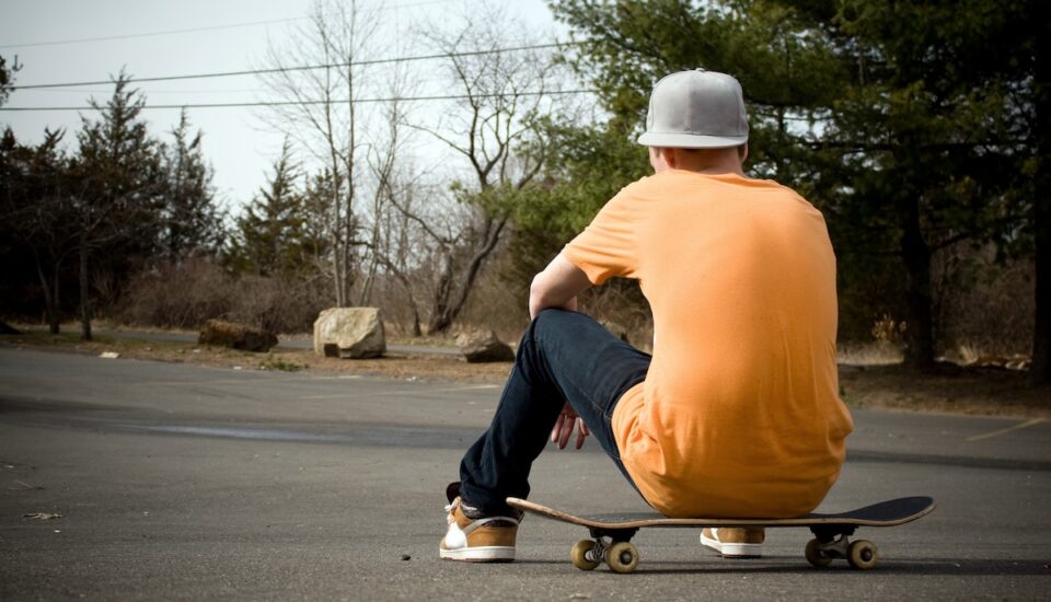 A young skater resting on his board.