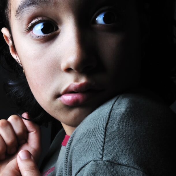 Dark image of a scared little girl who appears to be scared.