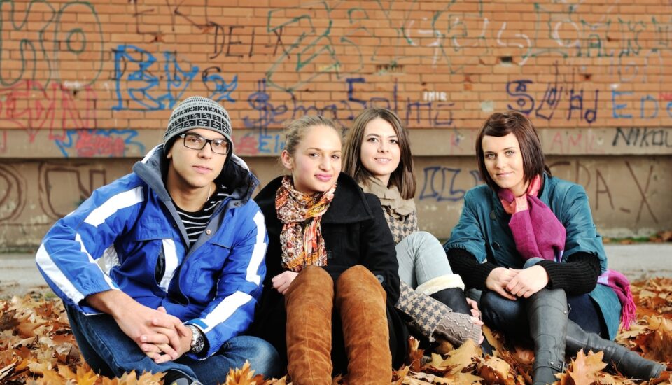 Group of adolescent teens together in a city.