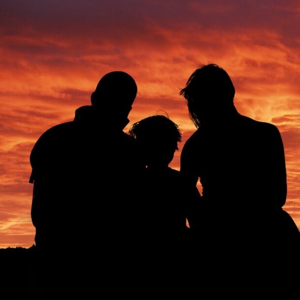 Outline of a family sitting in nature.