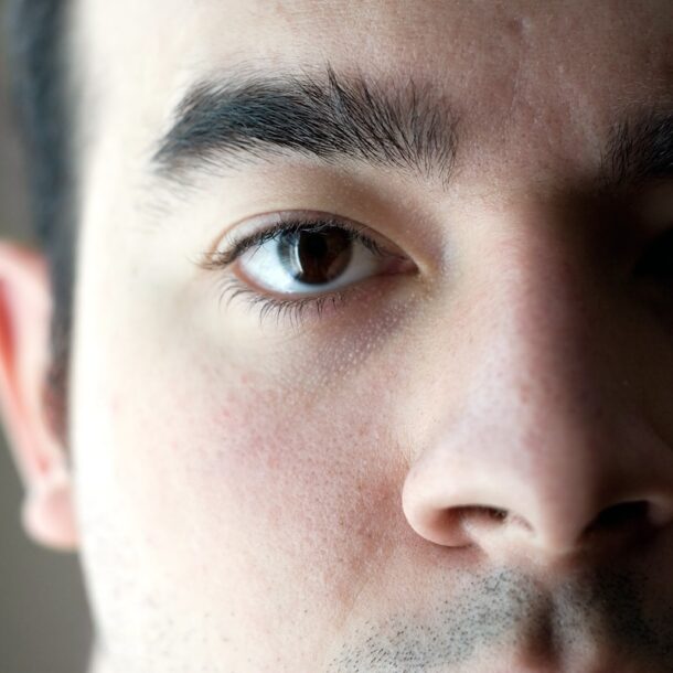 A closeup of the eye on a young man with a serious look on his face.